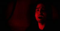 a man with his mouth open in a dark room