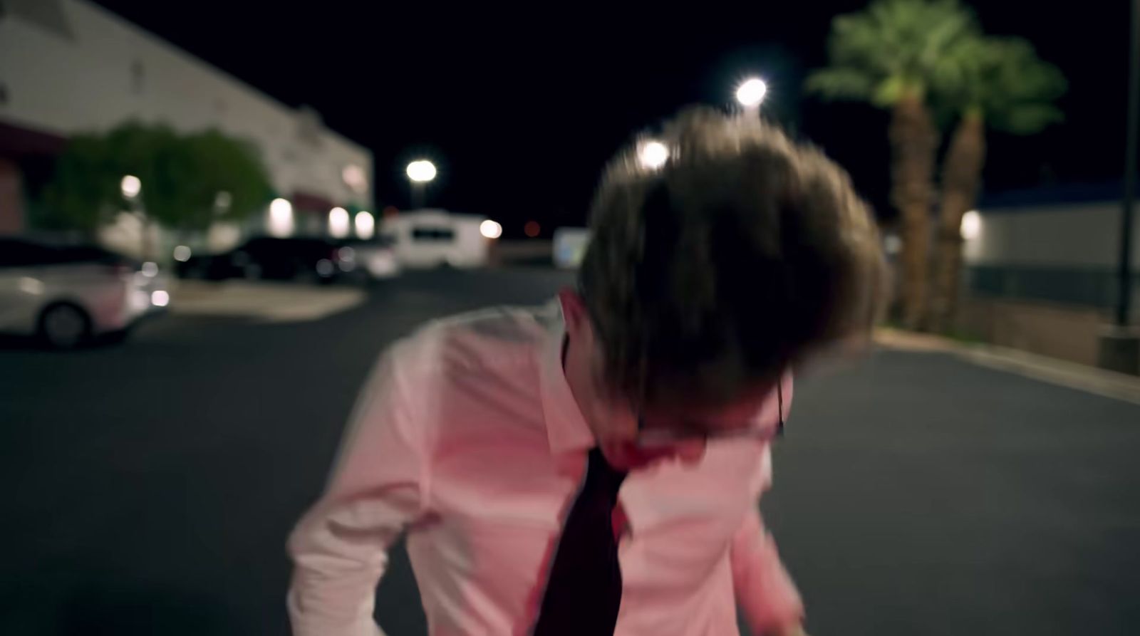 a woman walking down a street at night