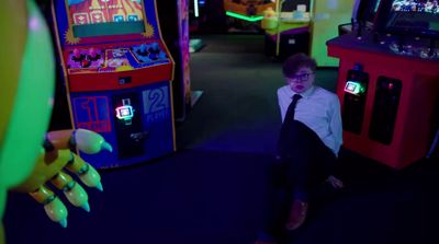 a young boy in a tie playing a video game