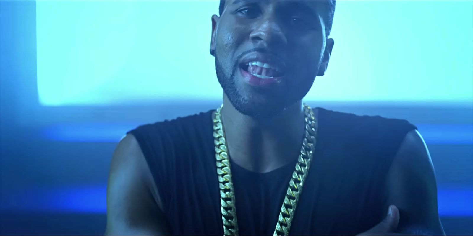 a man wearing a black shirt and a gold chain around his neck