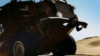 a large truck driving through a desert filled with sand