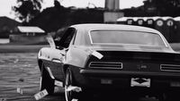 a black and white photo of a car parked on the street