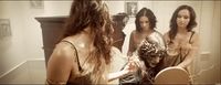 a group of women standing in front of a mirror