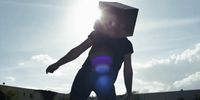 a person with a box on their head on a skateboard