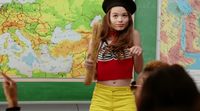 a girl in yellow shorts and a red top is standing in front of a map