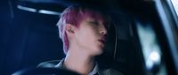 a person with pink hair sitting in a car