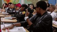 a group of people sitting at desks in a classroom