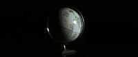 a black and white photo of a clock in the dark