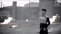 a woman standing in the middle of a dirt field