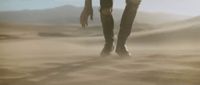 a person standing in the sand with their feet in the sand