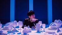 a woman sitting at a table with white dishes