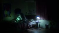 a person sitting on a bed in a dark room