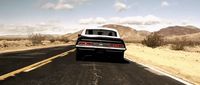 a black and white car driving down a desert road