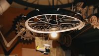 a ceiling lamp with a bicycle wheel hanging from it