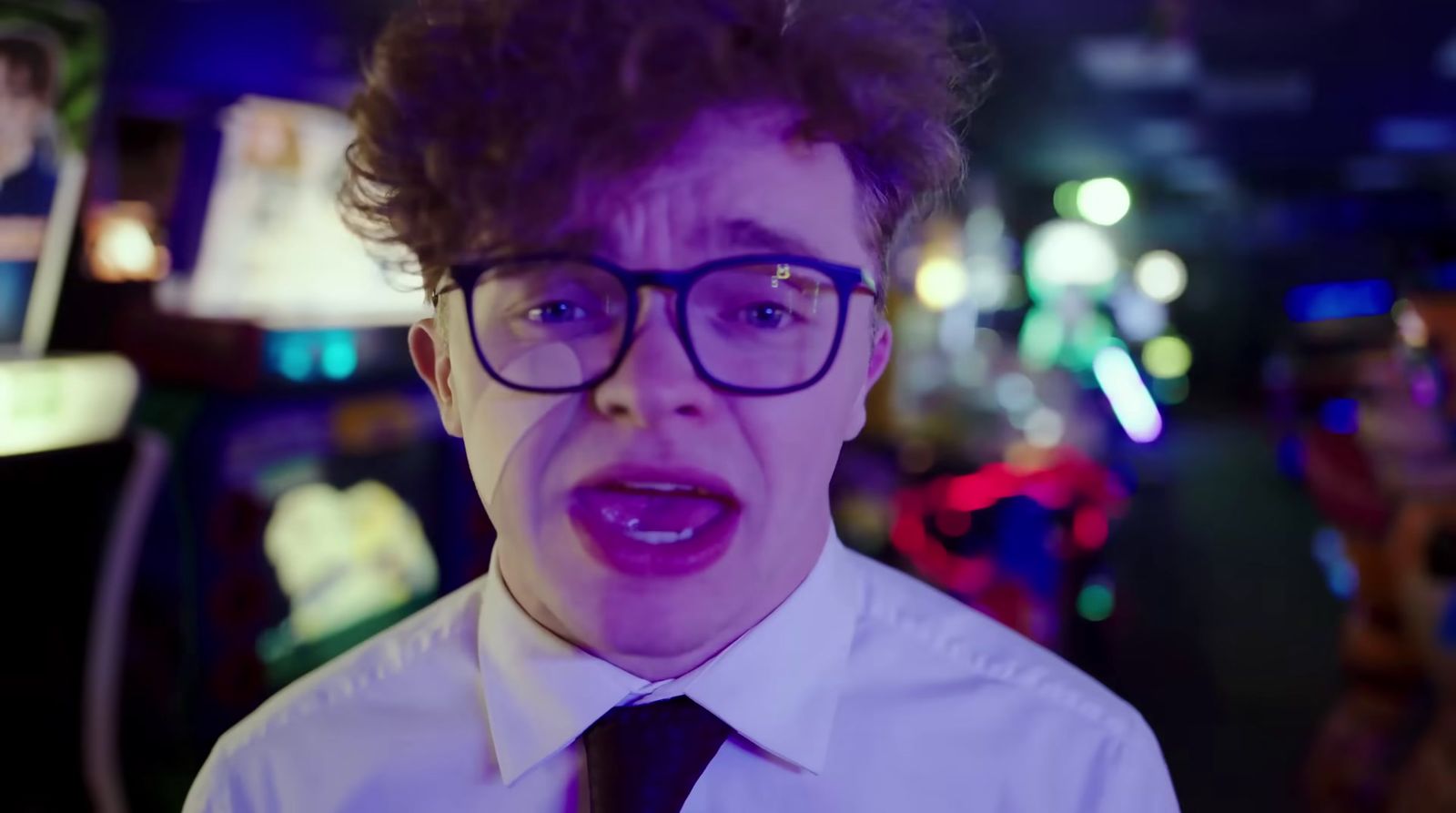 a young man wearing glasses and a tie