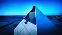 a man sitting on top of a blue pyramid