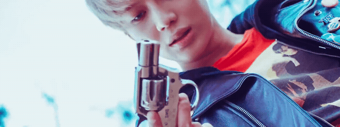 a young man holding a gun in his right hand
