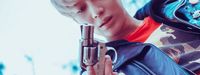 a young man holding a gun in his right hand