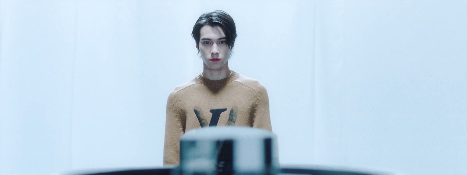 a man standing in front of a mirror wearing a sweater