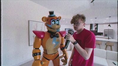 a man standing next to a robot holding a microphone