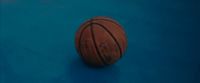 a close up of a basketball on a blue surface