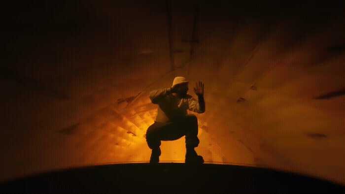 a man kneeling down in front of a light