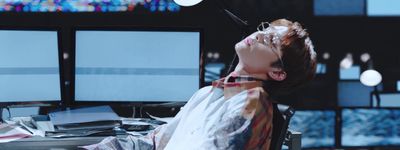 a person sitting at a desk in front of two monitors