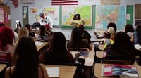 a group of people sitting at desks in a classroom