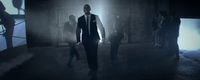 a man in a suit and tie walking in a dark room