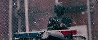 a person standing next to a fence in the snow