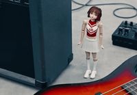 a doll is standing next to a guitar