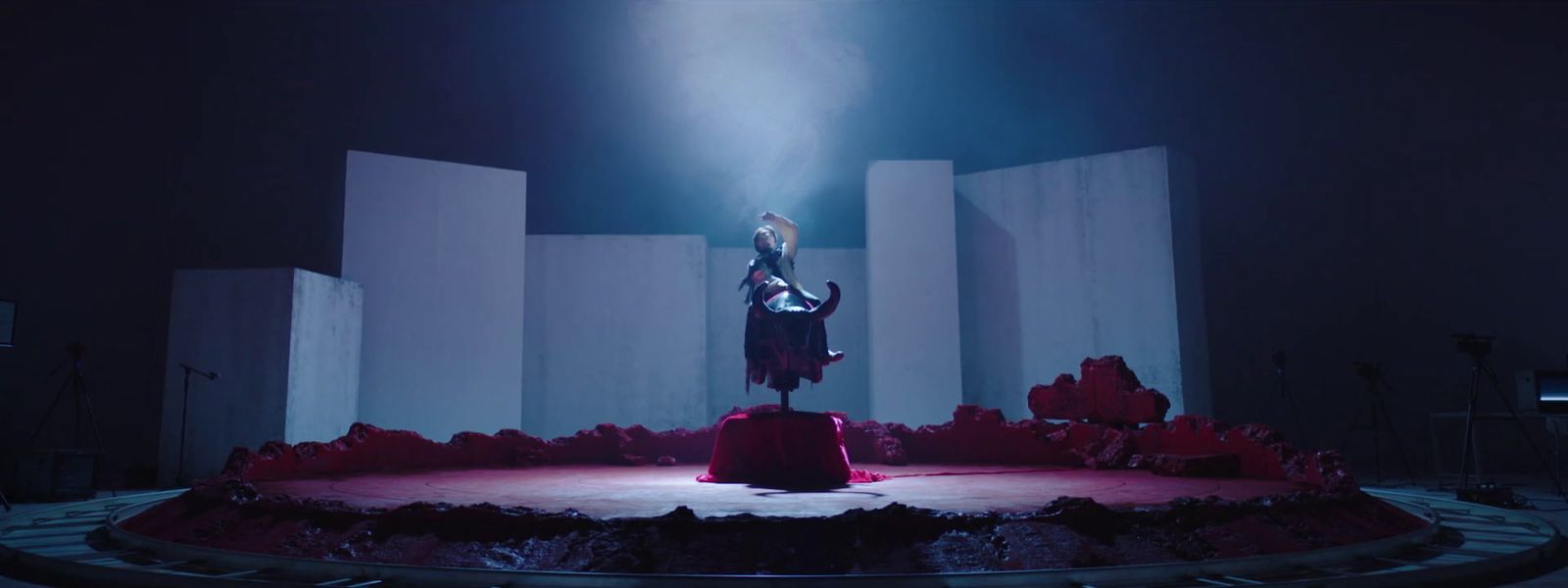 a woman standing on top of a stage in a dark room