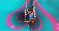 a woman sitting on a swing in front of a wall