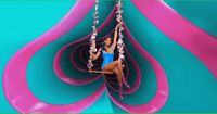 a woman in a blue swimsuit swinging on a swing