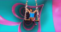 a woman sitting on a swing in front of a colorful background