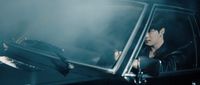 a man in a black leather jacket sitting in a car