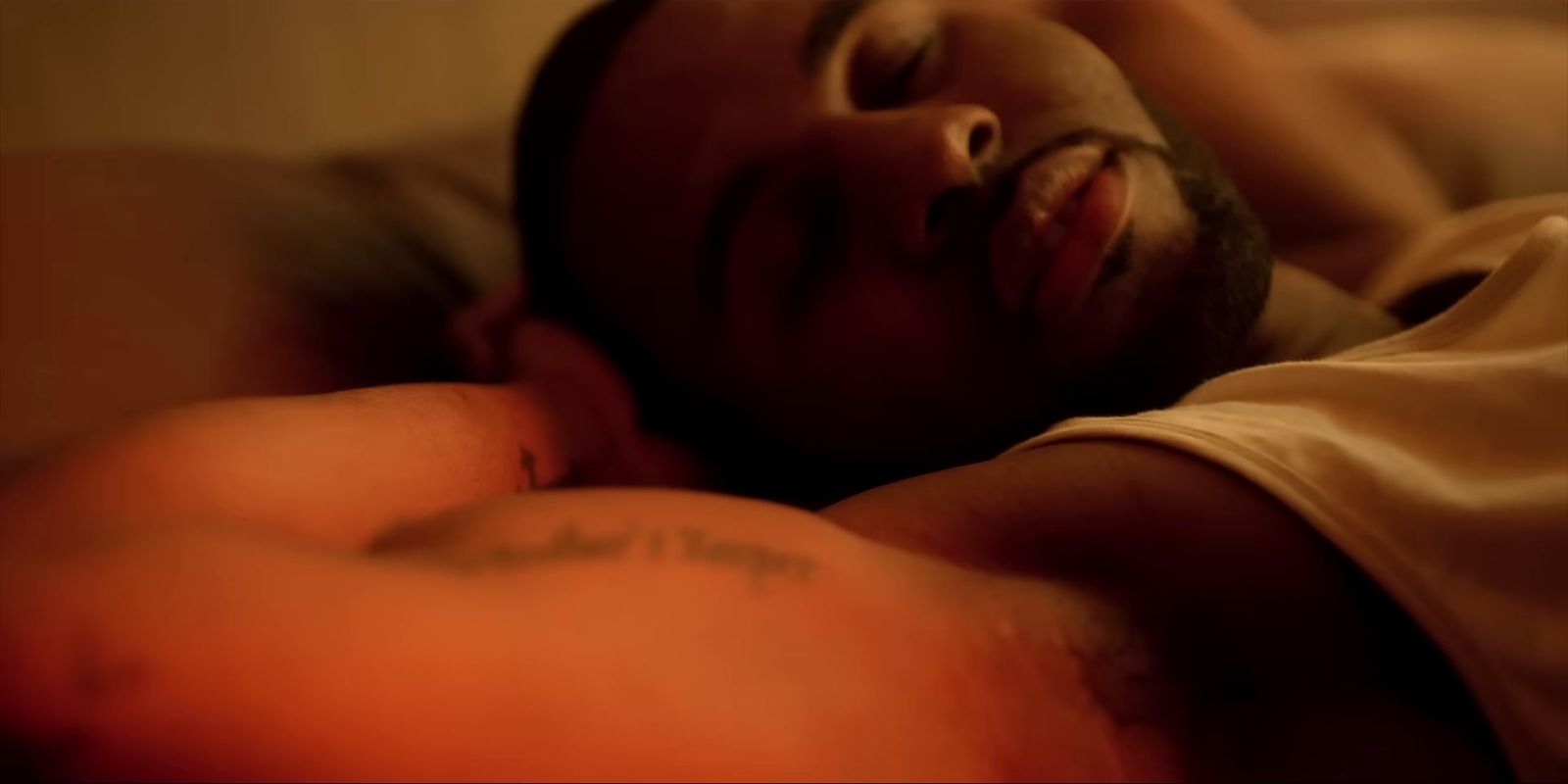 a man laying in bed with his eyes closed