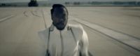 a man in a white shirt standing on a runway