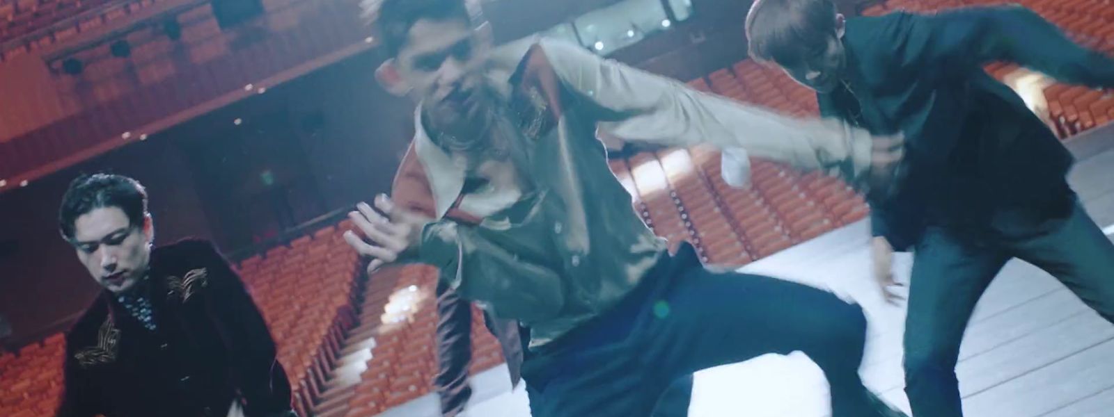 a group of young men dancing in an auditorium