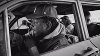 a black and white photo of a man in a car