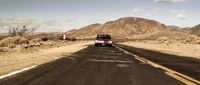 a van is driving down a desert road