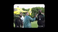 a group of men standing around a yellow helicopter