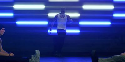 a man in a white tank top is walking down a runway