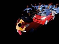 a group of people riding on top of a red car