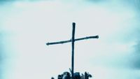 a cross on top of a building with a sky background