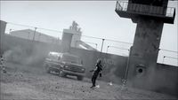 a woman standing in front of a truck on a dirt road