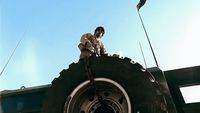 a man sitting on top of a large tire