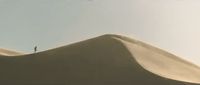 a person standing on top of a sand dune