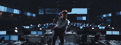 a man standing in a room full of computer monitors