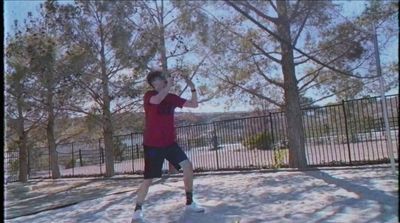 a man in a red shirt is playing frisbee in the snow